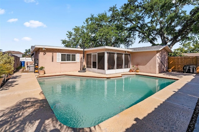 8763 Matthew St, Seminole, FL 33772 - back of property featuring a fenced in pool, stucco siding, a patio area, a fenced backyard, and a sunroom
