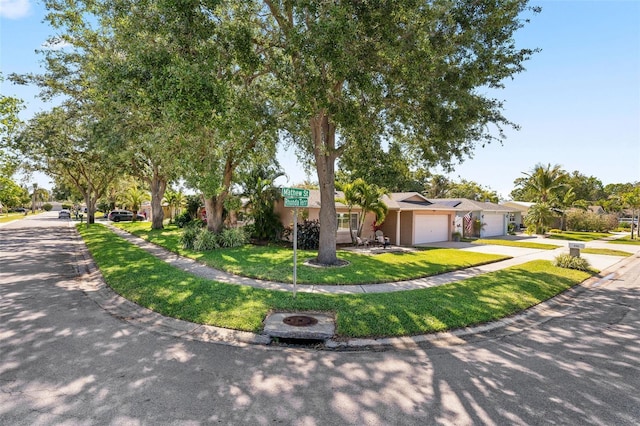 8763 Matthew St, Seminole, FL 33772 - ranch-style house with a front yard, driveway, a garage, and stucco siding
