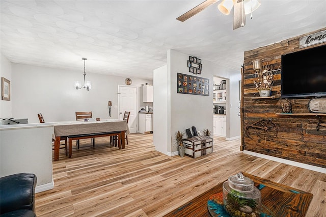186 Grand Ave, Brooksville, FL 34604 - living area with light wood-style flooring, a ceiling fan, a chandelier, and baseboards