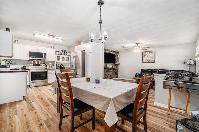 186 Grand Ave, Brooksville, FL 34604 - dining space with light wood-type flooring, ceiling fan, and a chandelier