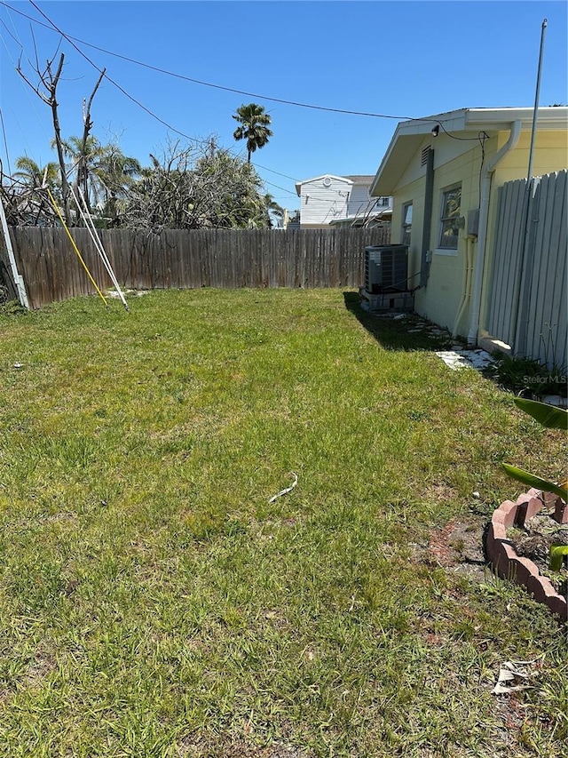 view of yard with central AC unit and fence