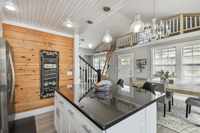 2704 W Main St, Tampa, FL 33607 - kitchen with white cabinets, dark countertops, a notable chandelier, wood finished floors, and stainless steel refrigerator with ice dispenser