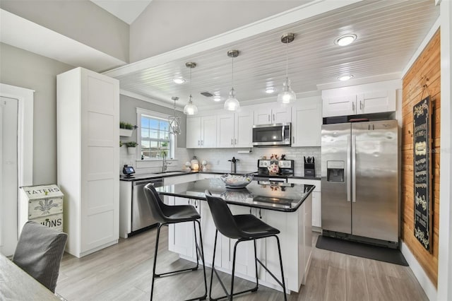 2704 W Main St, Tampa, FL 33607 - kitchen with dark countertops, appliances with stainless steel finishes, a sink, and light wood-style floors