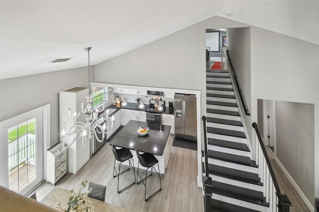2704 W Main St, Tampa, FL 33607 - interior space with a chandelier, wood finished floors, visible vents, and high vaulted ceiling