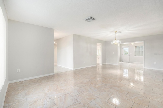 4120 Marine Pkwy, New Port Richey, FL 34652 - spare room featuring visible vents, baseboards, an inviting chandelier, and a textured ceiling