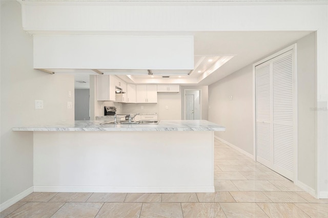 4120 Marine Pkwy, New Port Richey, FL 34652 - kitchen with baseboards, a peninsula, light countertops, white cabinets, and stainless steel electric stove