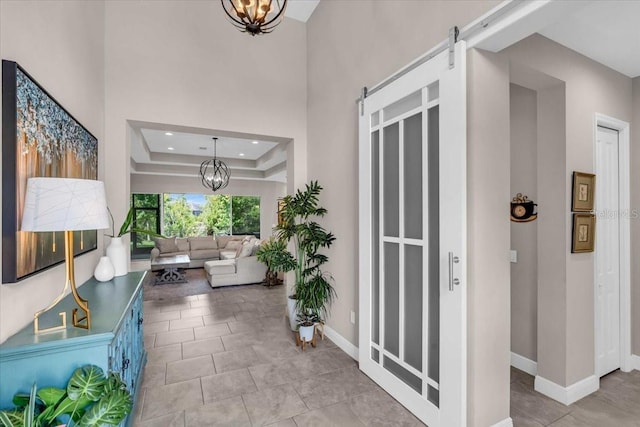 foyer with recessed lighting, a notable chandelier, baseboards, and a barn door