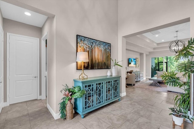 hallway featuring recessed lighting, baseboards, and an inviting chandelier