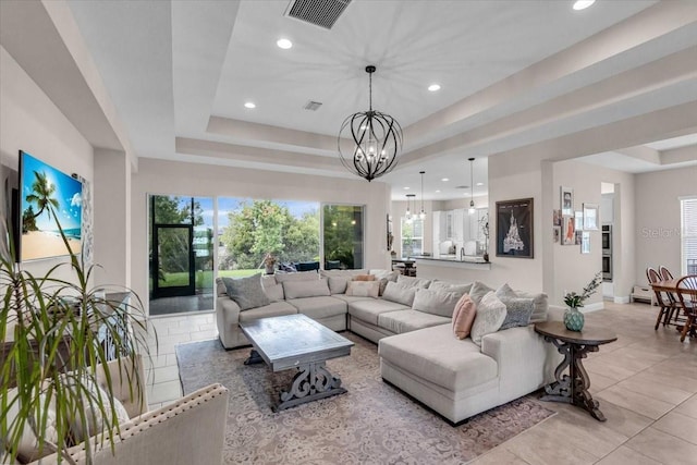 living room with visible vents, light tile patterned floors, a raised ceiling, an inviting chandelier, and recessed lighting