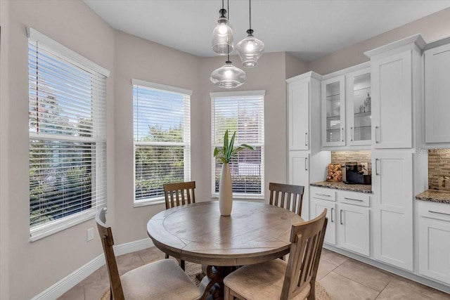 dining space featuring light tile patterned floors and baseboards