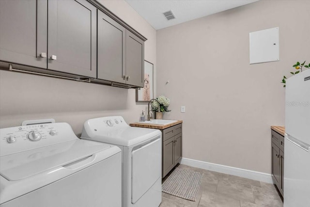 laundry room with separate washer and dryer, baseboards, visible vents, cabinet space, and a sink