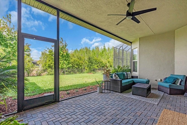 sunroom / solarium featuring ceiling fan, a wealth of natural light, and an outdoor hangout area