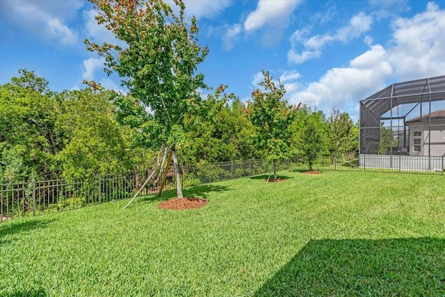 view of yard featuring a fenced backyard and a lanai