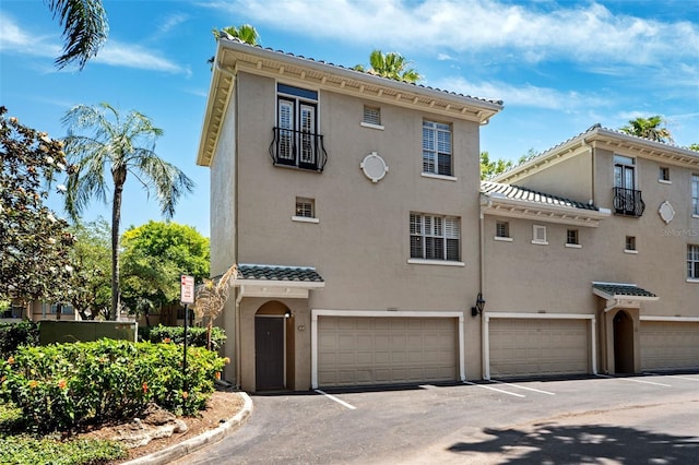 view of front of house with a garage, stucco siding, and driveway