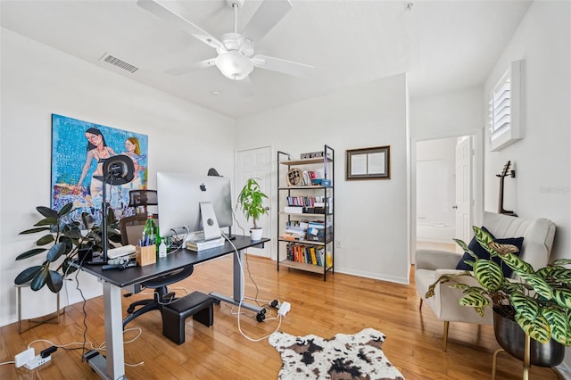 office area with light wood finished floors, visible vents, baseboards, and ceiling fan