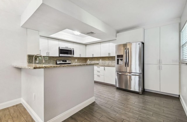 kitchen with wood finished floors, white cabinetry, visible vents, and stainless steel appliances