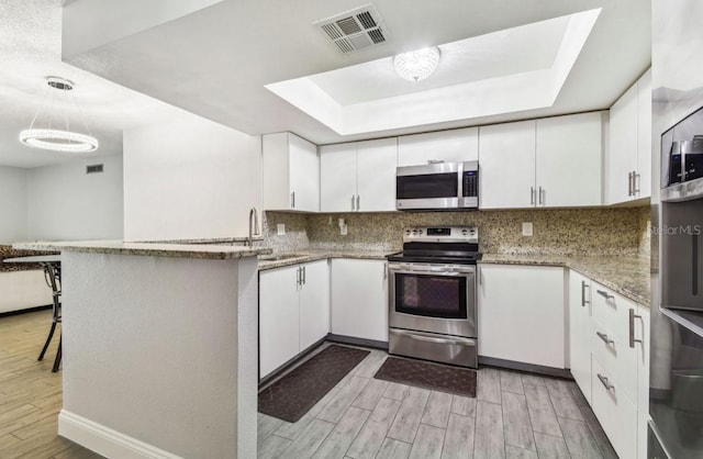 kitchen with visible vents, a sink, light wood-type flooring, white cabinetry, and stainless steel appliances
