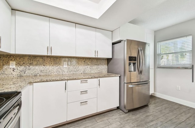 kitchen featuring tasteful backsplash, baseboards, white cabinetry, stainless steel appliances, and light wood finished floors