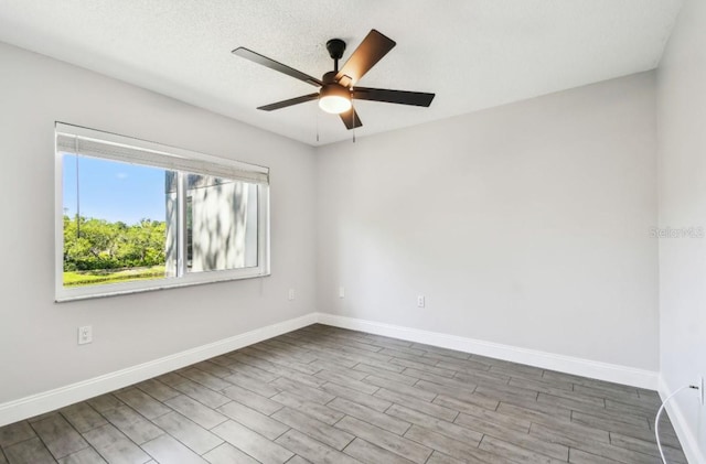 empty room featuring baseboards, a ceiling fan, and wood finished floors