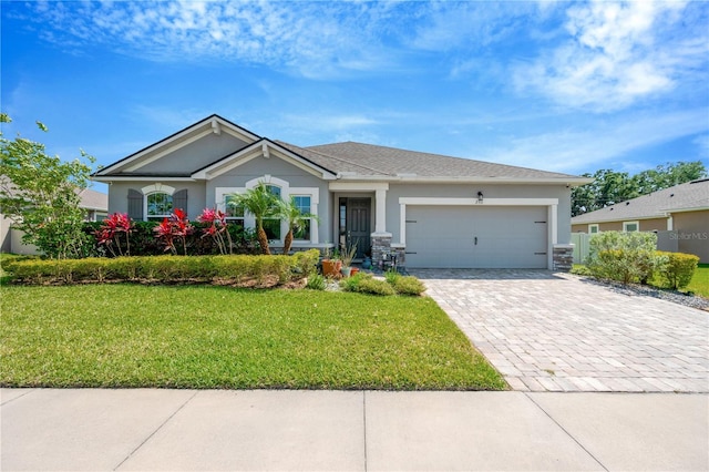 2511 Early Dawn Ct, Valrico, FL 33594 - view of front of home featuring stone siding, a garage, a front yard, stucco siding, and decorative driveway