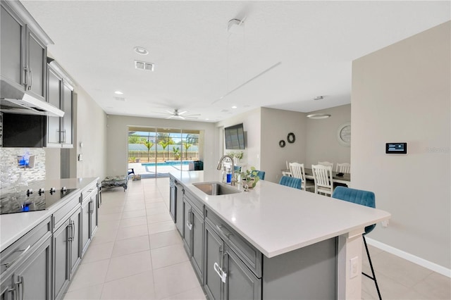 2511 Early Dawn Ct, Valrico, FL 33594 - kitchen with a sink, visible vents, a kitchen bar, gray cabinets, and black electric stovetop
