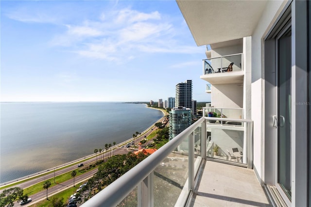 balcony featuring a water view and a city view