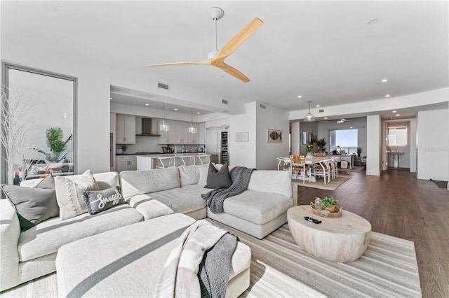 living area featuring dark wood-type flooring, visible vents, recessed lighting, and a ceiling fan