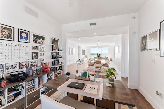 living area featuring visible vents, baseboards, and wood finished floors