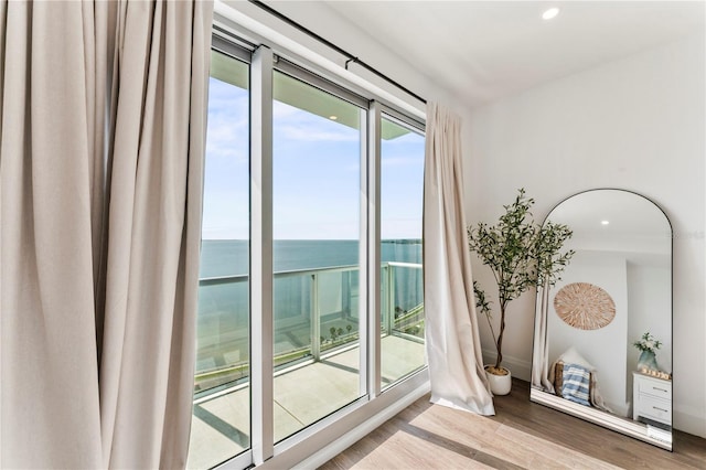 interior space with wood finished floors, recessed lighting, baseboards, and a water view
