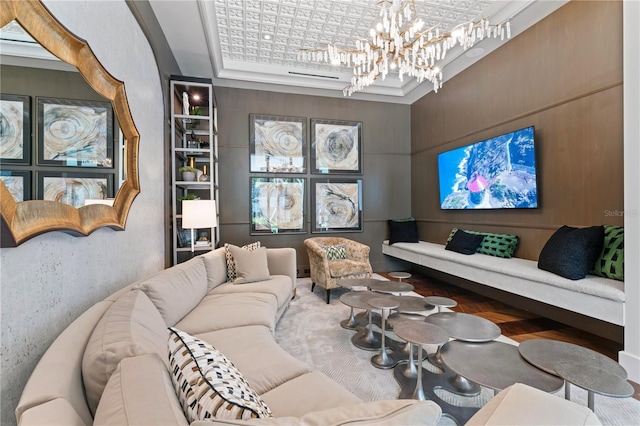 living room with a chandelier, a raised ceiling, and wood finished floors