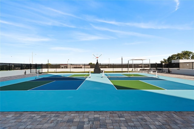 view of basketball court featuring a tennis court, fence, and community basketball court