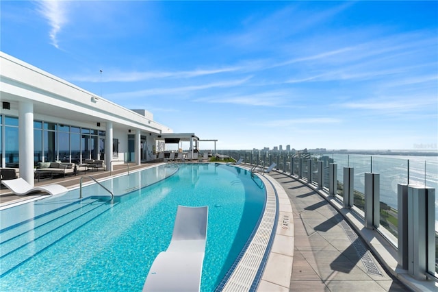 pool with an outdoor living space, a diving board, and a patio