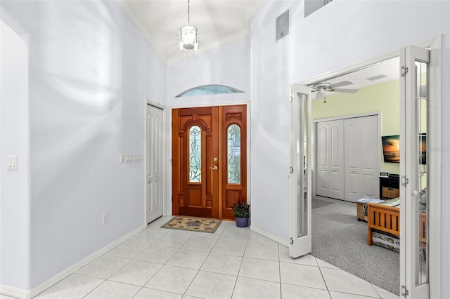 187 Sage Cir, Crystal Beach, FL 34681 - foyer featuring crown molding, a high ceiling, baseboards, light tile patterned floors, and a ceiling fan