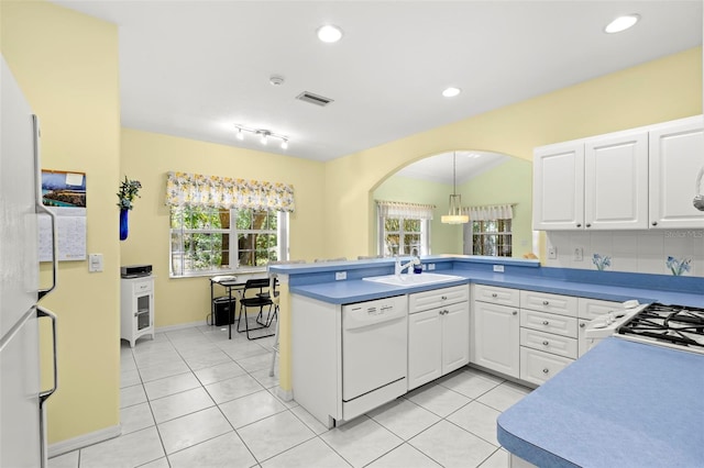 187 Sage Cir, Crystal Beach, FL 34681 - kitchen with white appliances, a sink, a peninsula, arched walkways, and white cabinets