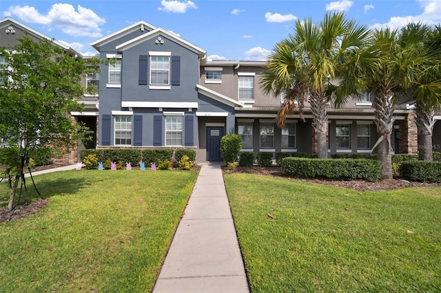 multi unit property with stucco siding and a front lawn
