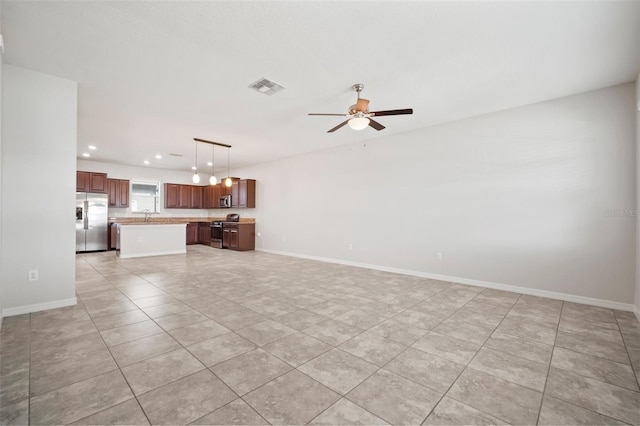 unfurnished living room with visible vents, light tile patterned floors, a sink, a ceiling fan, and recessed lighting