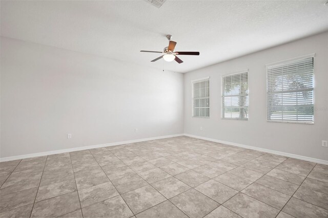 unfurnished room with light tile patterned flooring, baseboards, and a ceiling fan