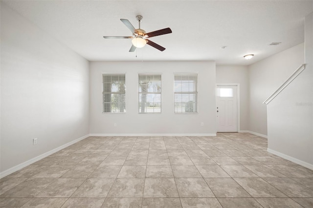 spare room featuring light tile patterned flooring, baseboards, and a ceiling fan