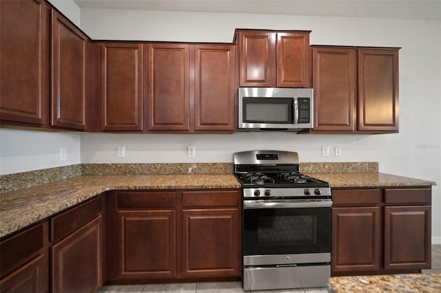 kitchen featuring stainless steel appliances and dark stone counters