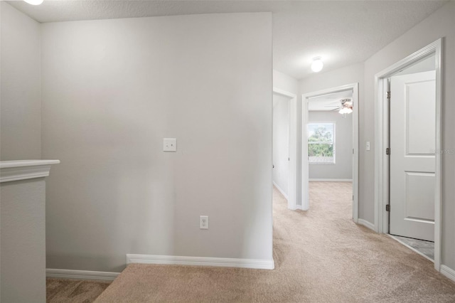 hallway with baseboards and carpet