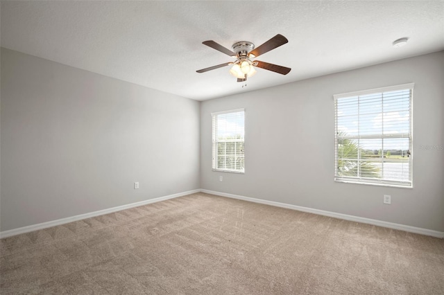 spare room featuring baseboards, a ceiling fan, and carpet