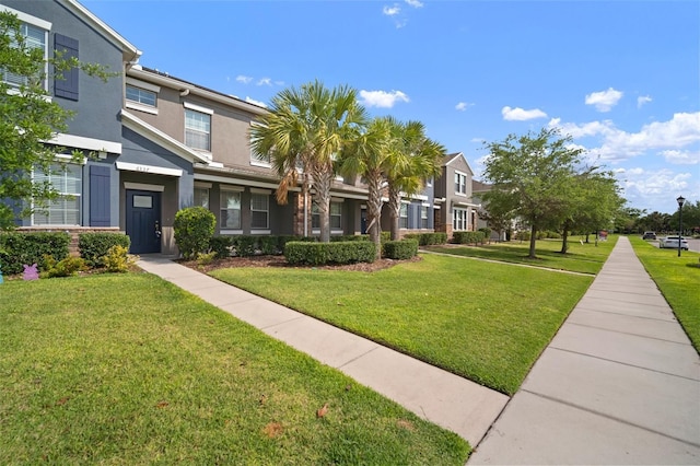 view of front of home with stucco siding and a front lawn