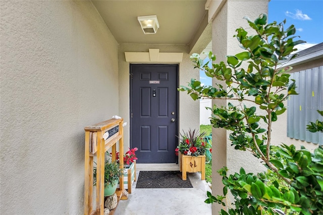 entrance to property featuring stucco siding