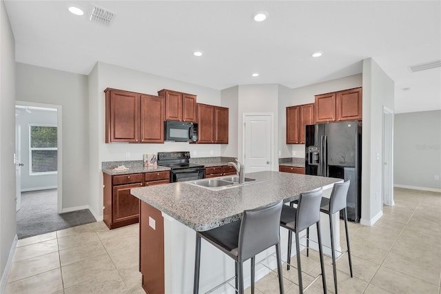 kitchen featuring baseboards, visible vents, a sink, and black appliances