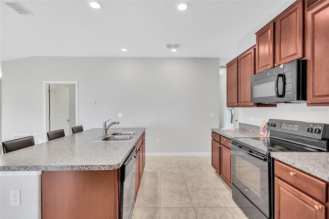 kitchen featuring baseboards, a sink, a kitchen island with sink, black appliances, and light tile patterned flooring