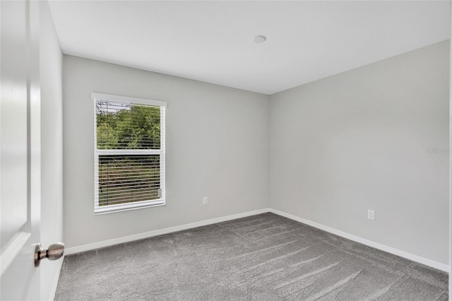 carpeted empty room with baseboards