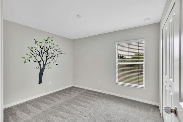 unfurnished bedroom with a closet, baseboards, and carpet