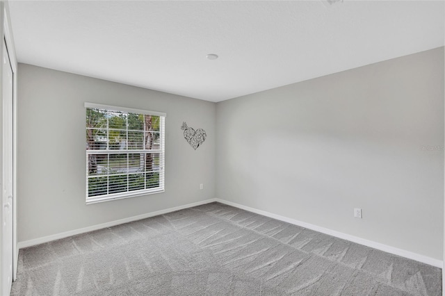 empty room with carpet and baseboards