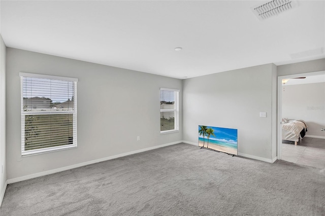 empty room featuring carpet flooring, baseboards, and visible vents