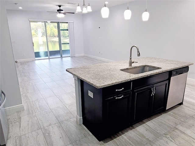 5509 Cumberland Star Ct, Lutz, FL 33558 - kitchen featuring a sink, dishwasher, dark cabinetry, and baseboards